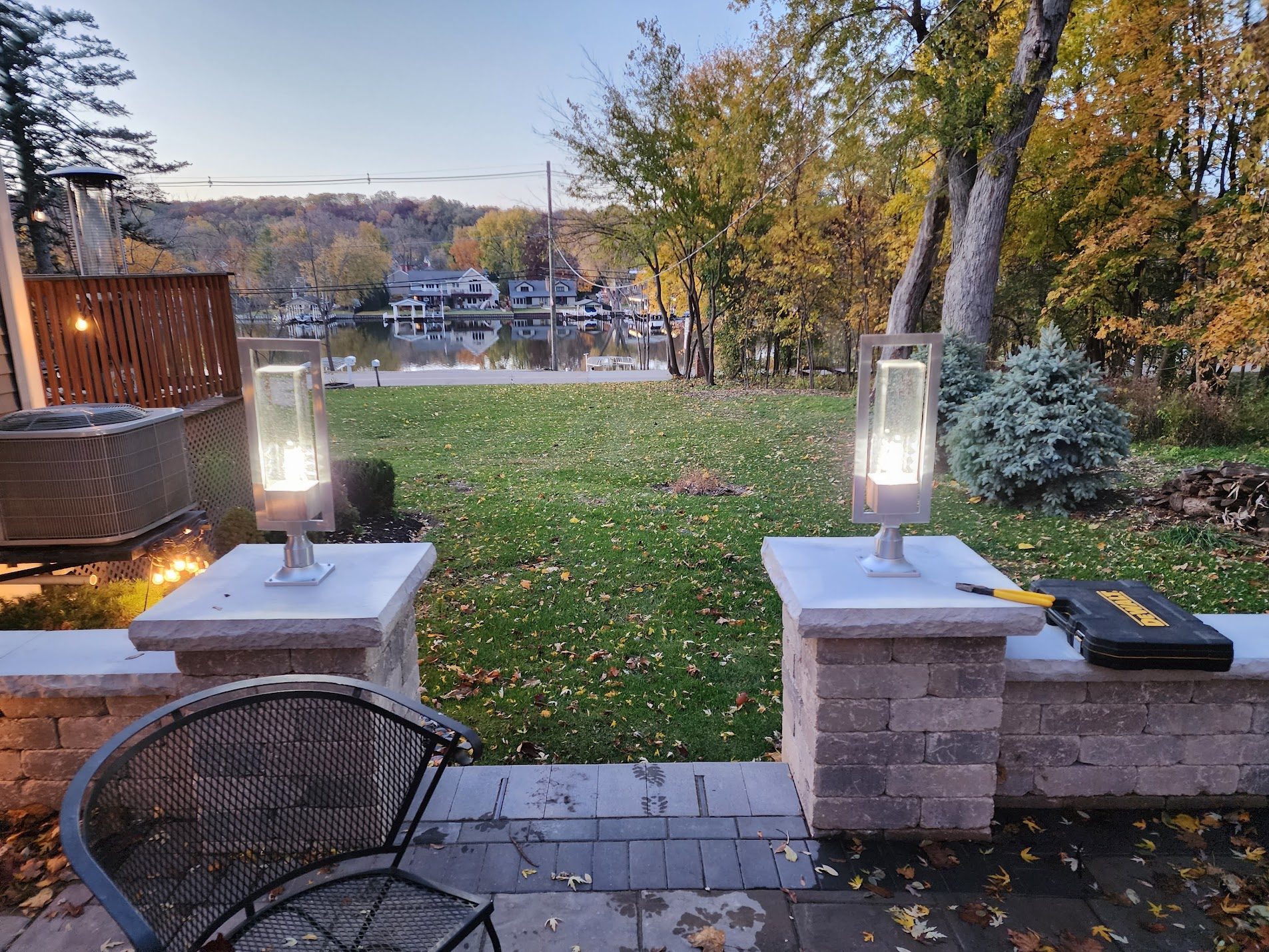 Copper fire pit with lit stone columns at dusk